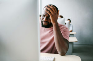 Upset, Sad Man Is Sitting At Computer. Job Search, Crisis, Unsta